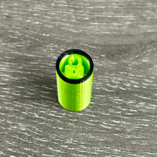 Photo of the contents are laid out a table displaying a neon green with black outline hemp made filter tip that is reusable.